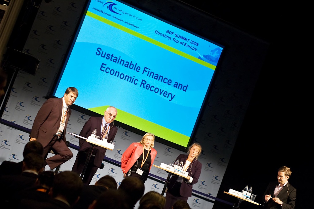En paneldiskussion om hållbar finansiering och ekonomisk återhämtning med experter på scen.